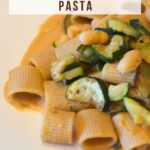 Pinterest image with a photo of a pasta dish and a caption reading "Creamy zucchini and cannellini bean pasta".